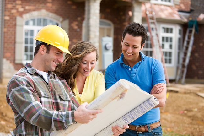 Construction worker with family looking at blue prints