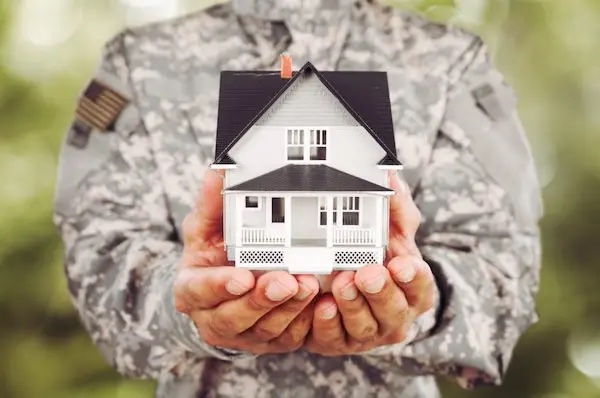 Military person holding a model house