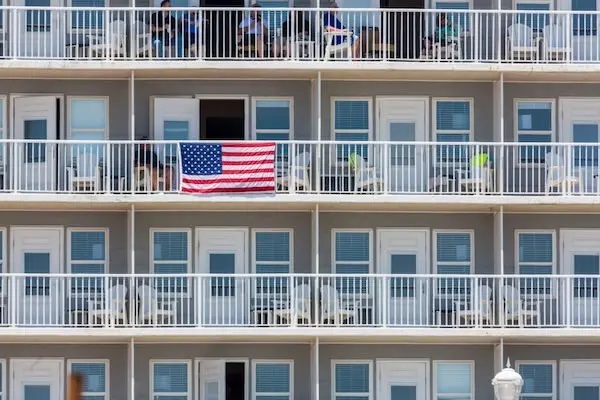 The front of a condo complex with an American flag